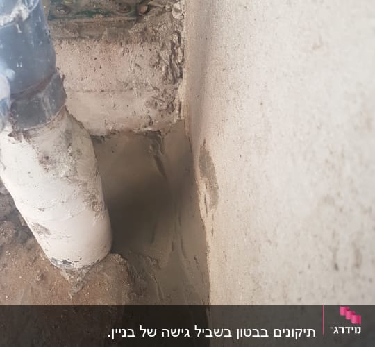 צינור לבן ליד קיר עם טיח טרי